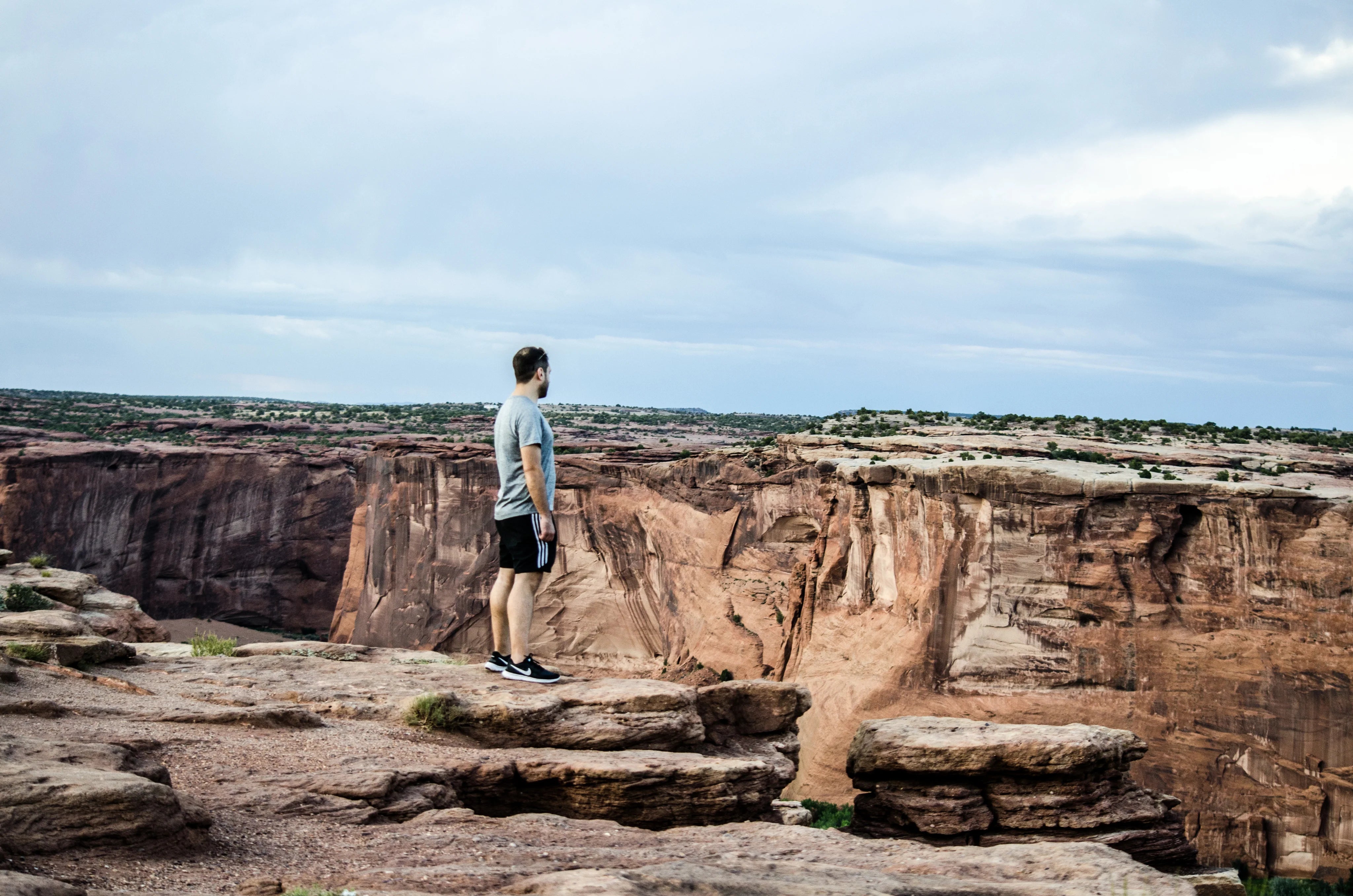 files/a-man-on-a-rocky-plateau-overlooks-a-deep-canyon.webp